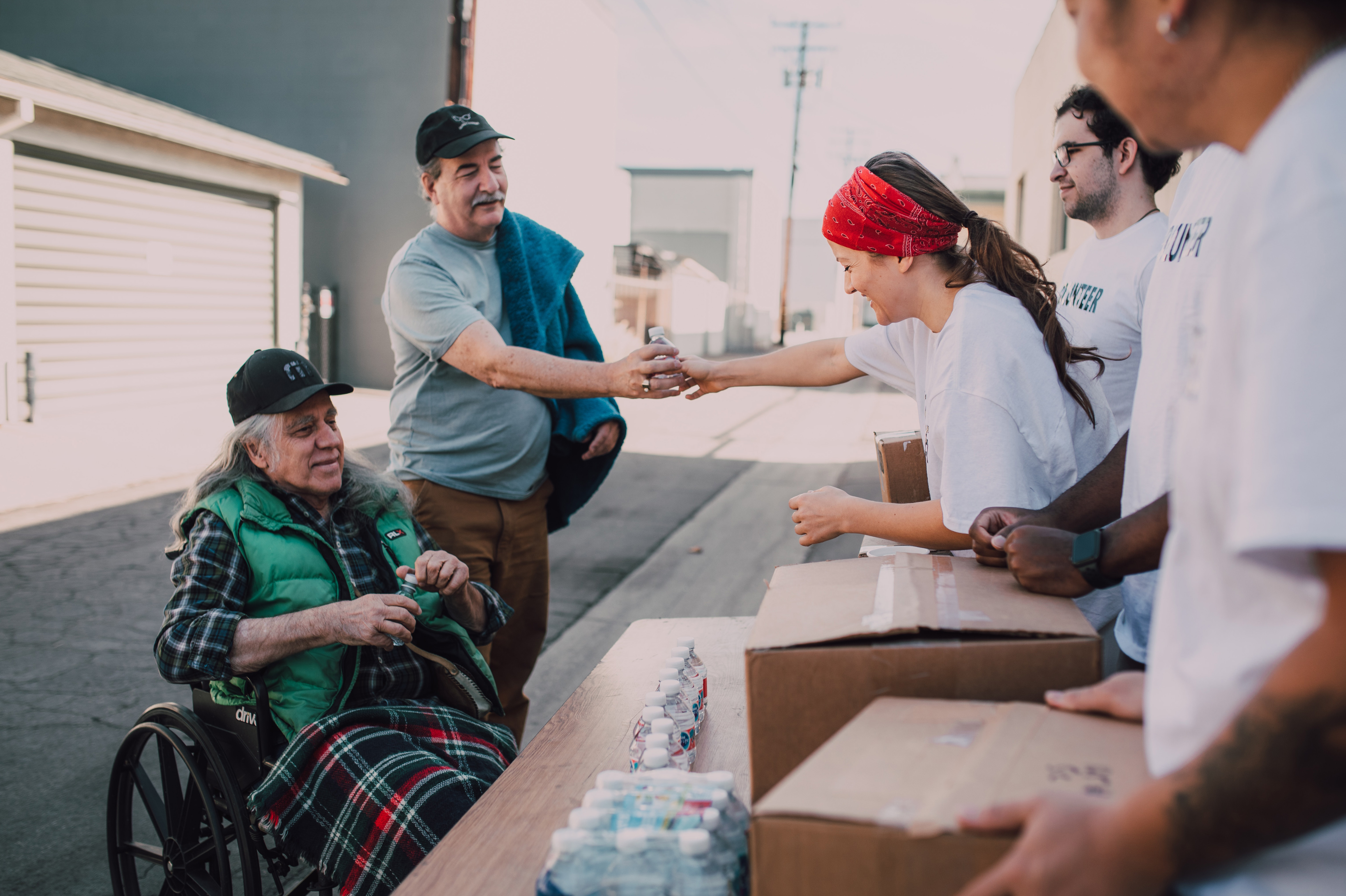 Volunteers handing out food and water bottles at a food bank.