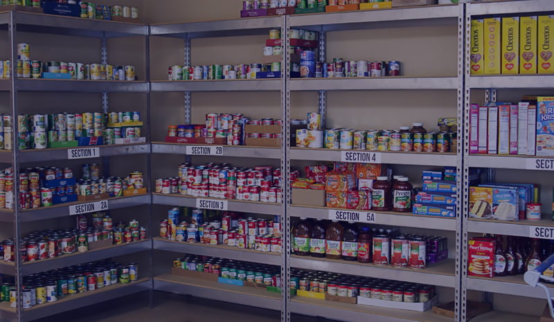 Background image of a food bank with cans of soup and vegetables 