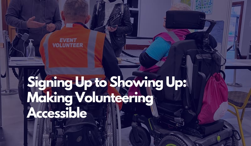 Background image of two volunteers in wheelchairs checking people in with text overlayed reading From Signing Up to Showing Up: Making Volunteering Accessible 