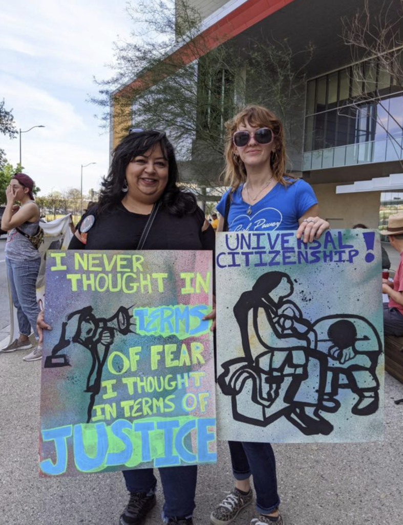 Members from RAICES protesting with signs that read: "I never thought in terms of fear, I thought in terms of justice" and "Universal citizenship"