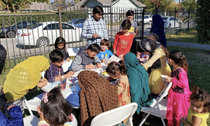 Group of families from RAICES working together on crafts outside