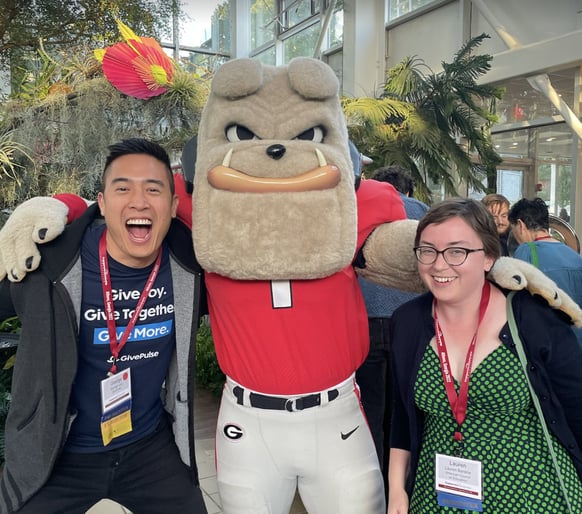 George and Lauren smiling with the University of Georgia Bulldog mascot at the Engaged Scholarship Consortium conference in 2022
