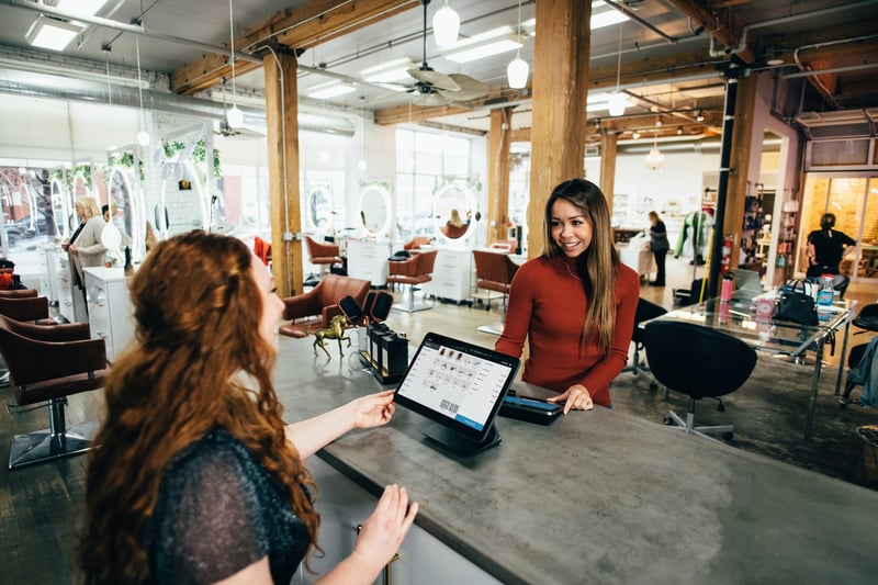Two women having a conversation over a table.