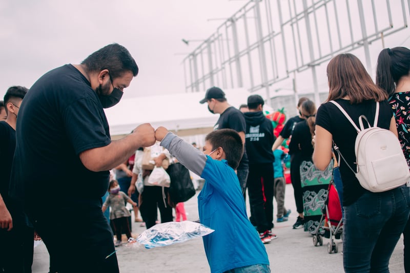 Volunteer and student fist bumping at a nonprofit event