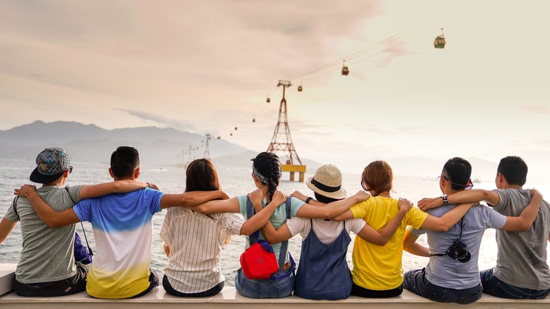 Eight students sitting with their arms across each others shoulders