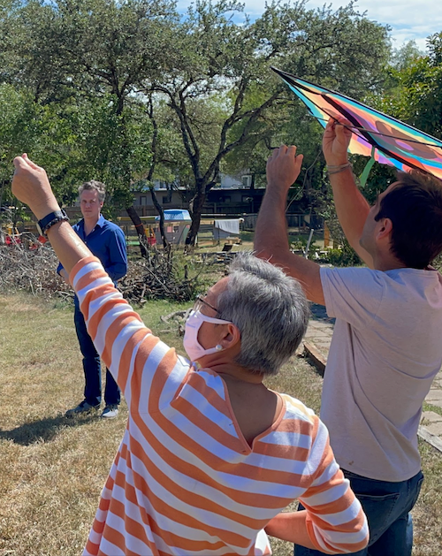 GivePulse staff volunteering and flying a kite (a symbol of showing what we can do in partnership with community). 