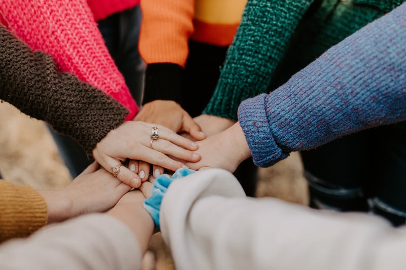Students putting their hands in a "hand huddle" 
