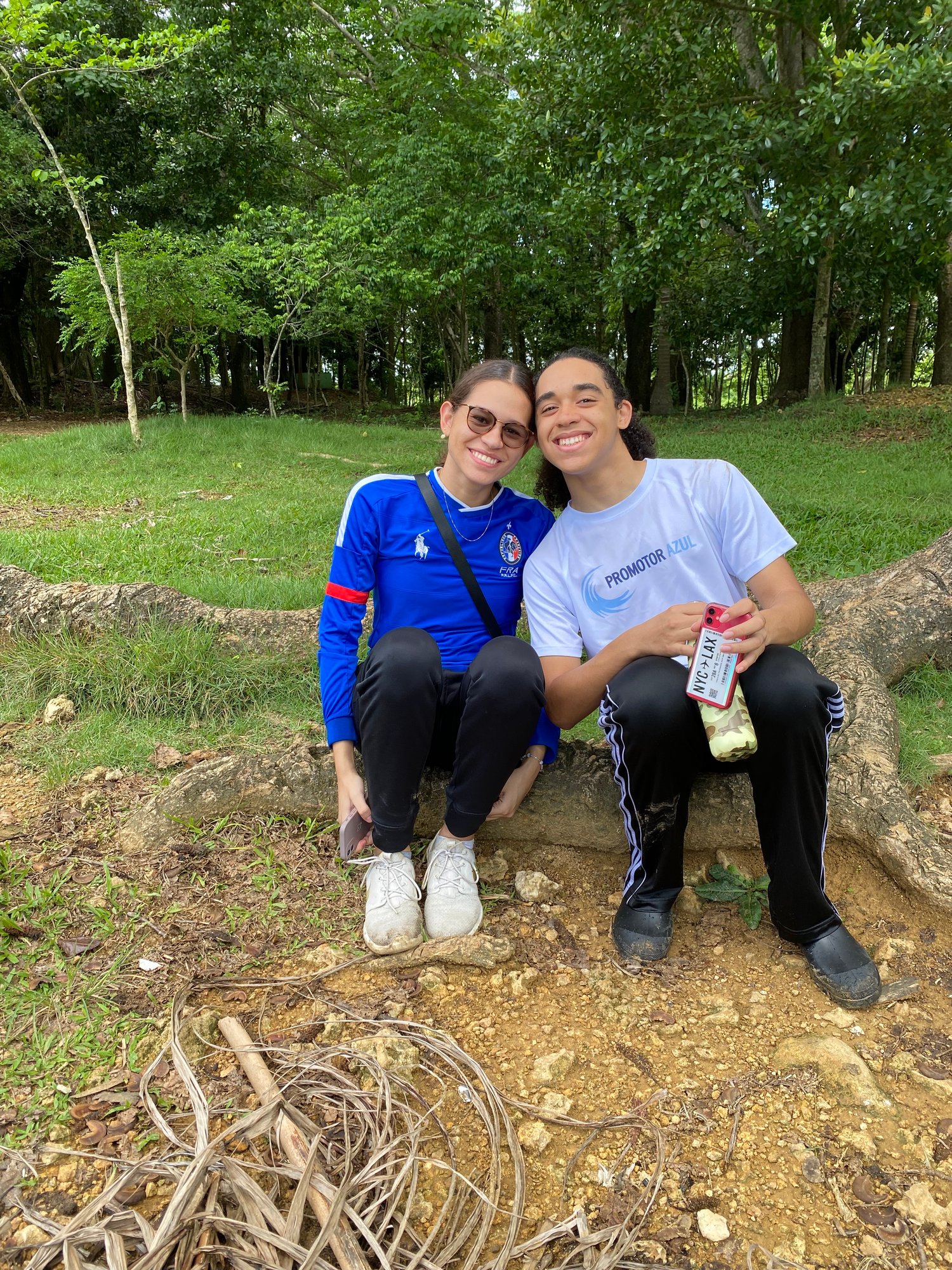 Two volunteers sitting during an event smiling at the camera 