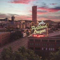 City scape of Portland Oregon with a neon sign reading 