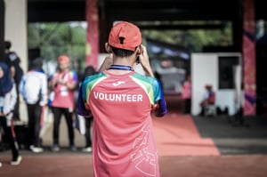 Volunteer with back facing towards the camera taking a picture of a nonprofit volunteer event