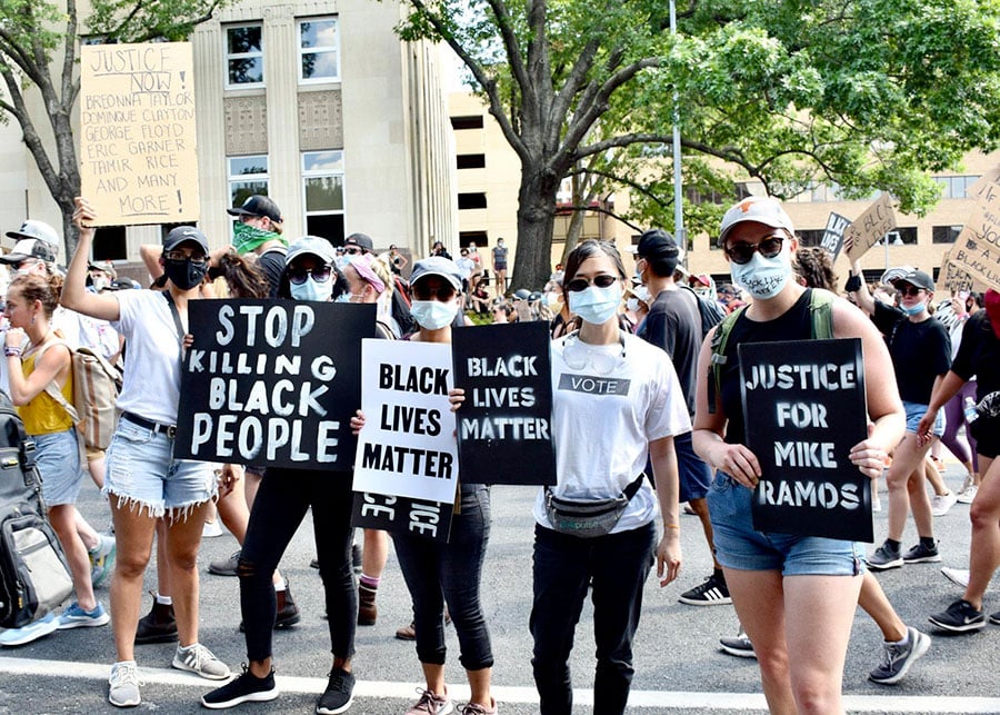 Team members protesting holding signs reading 