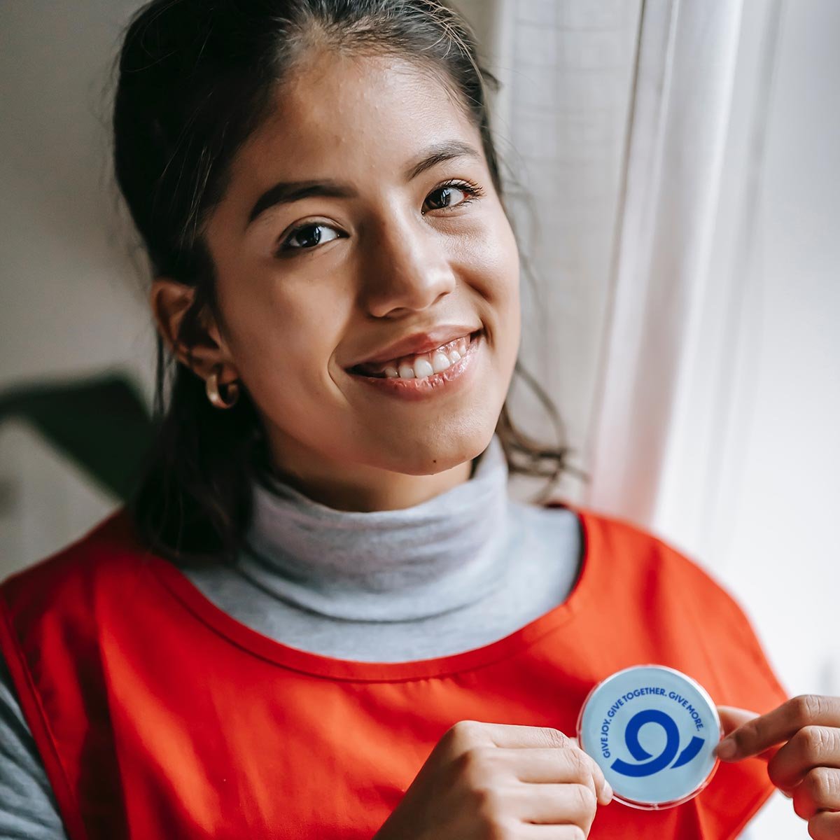 Volunteer smiling wearing a GivePulse pin