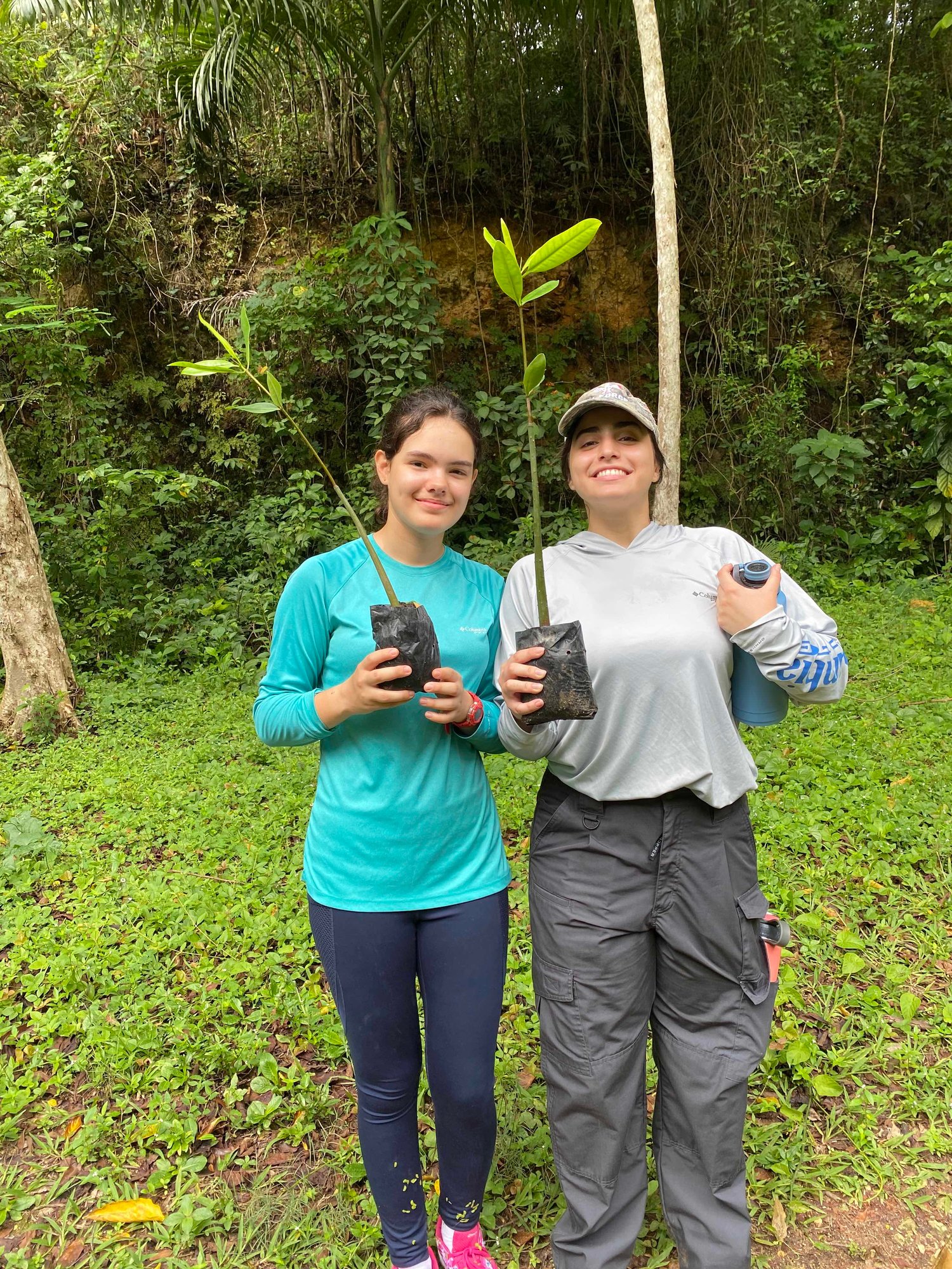 Two volunteers helping to plant trees in their community