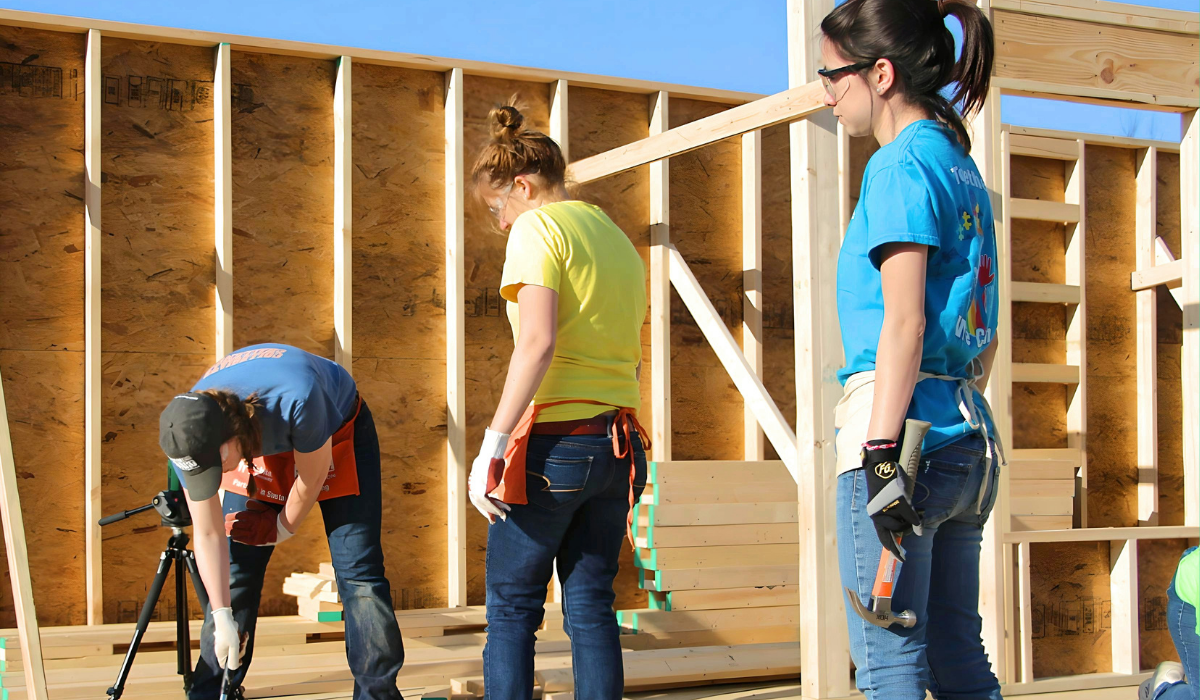 Blog cover image showing volunteers building a home together. 