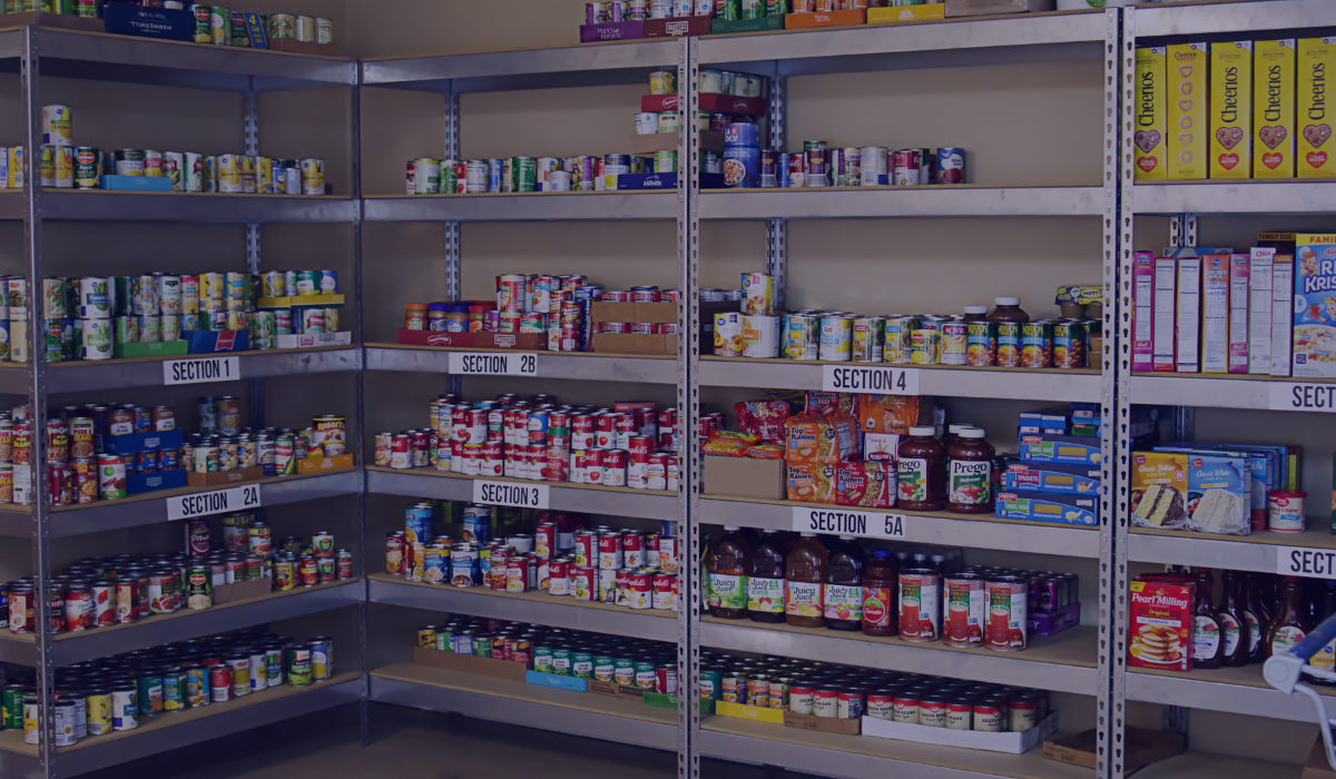 Background image of a food bank with cans of soup and vegetables 
