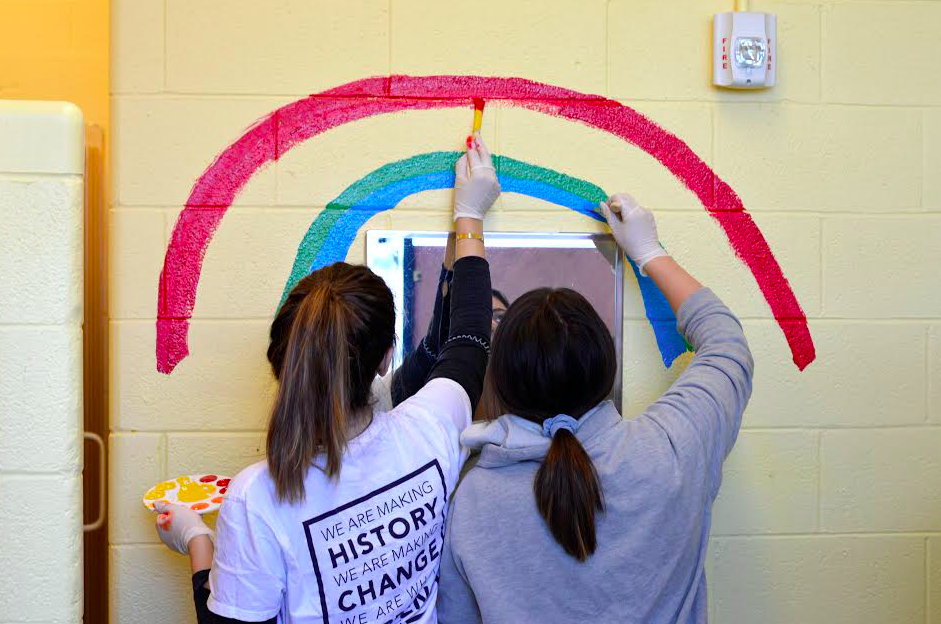 Two student volunteers helping to paint their school