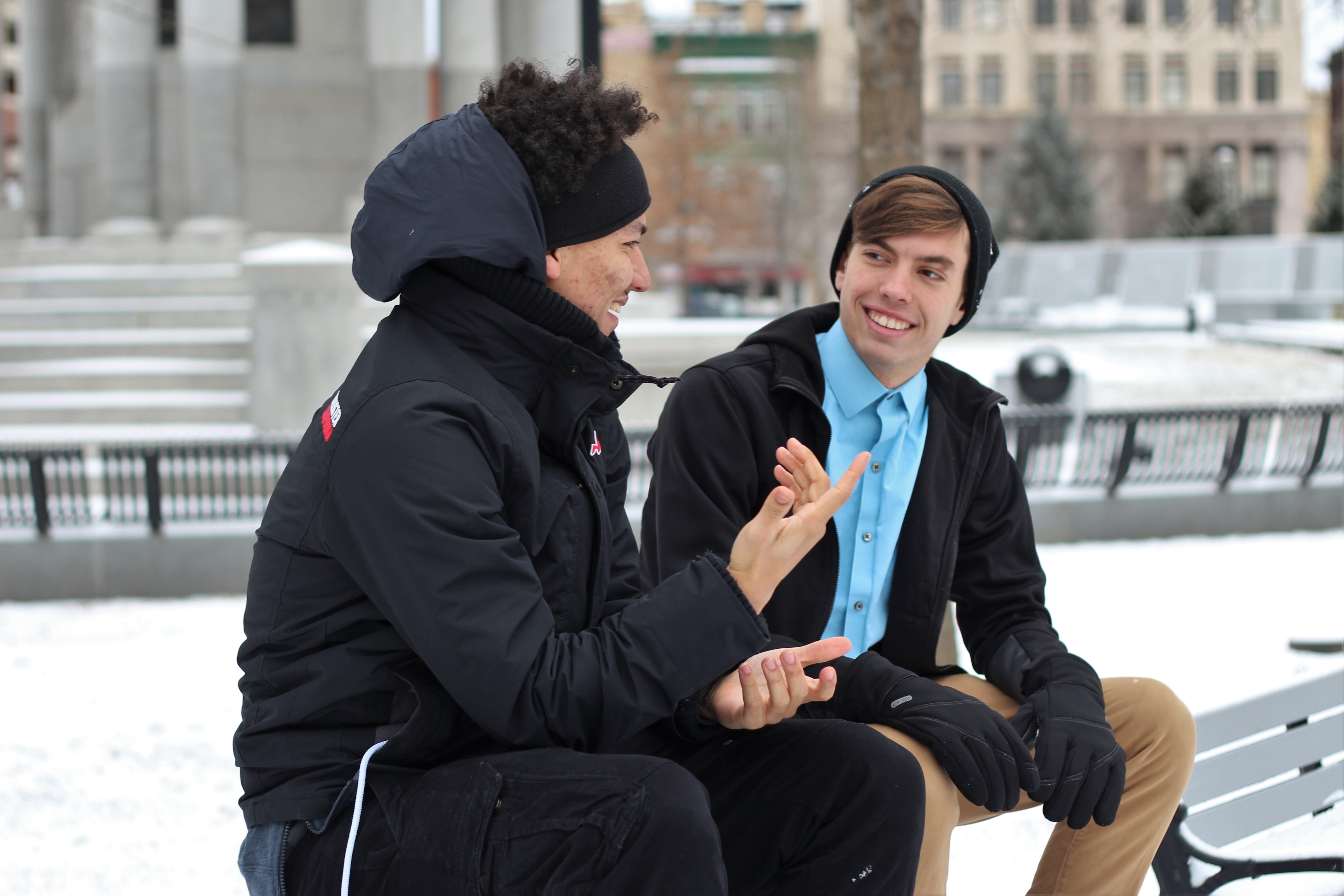 Two students sitting on a bench talking 