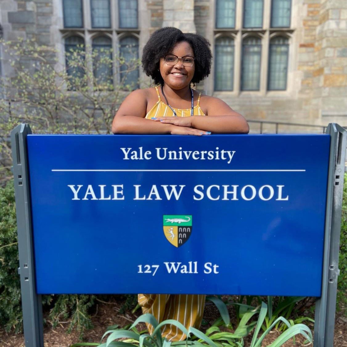 A girl in front of Yale Law School sign