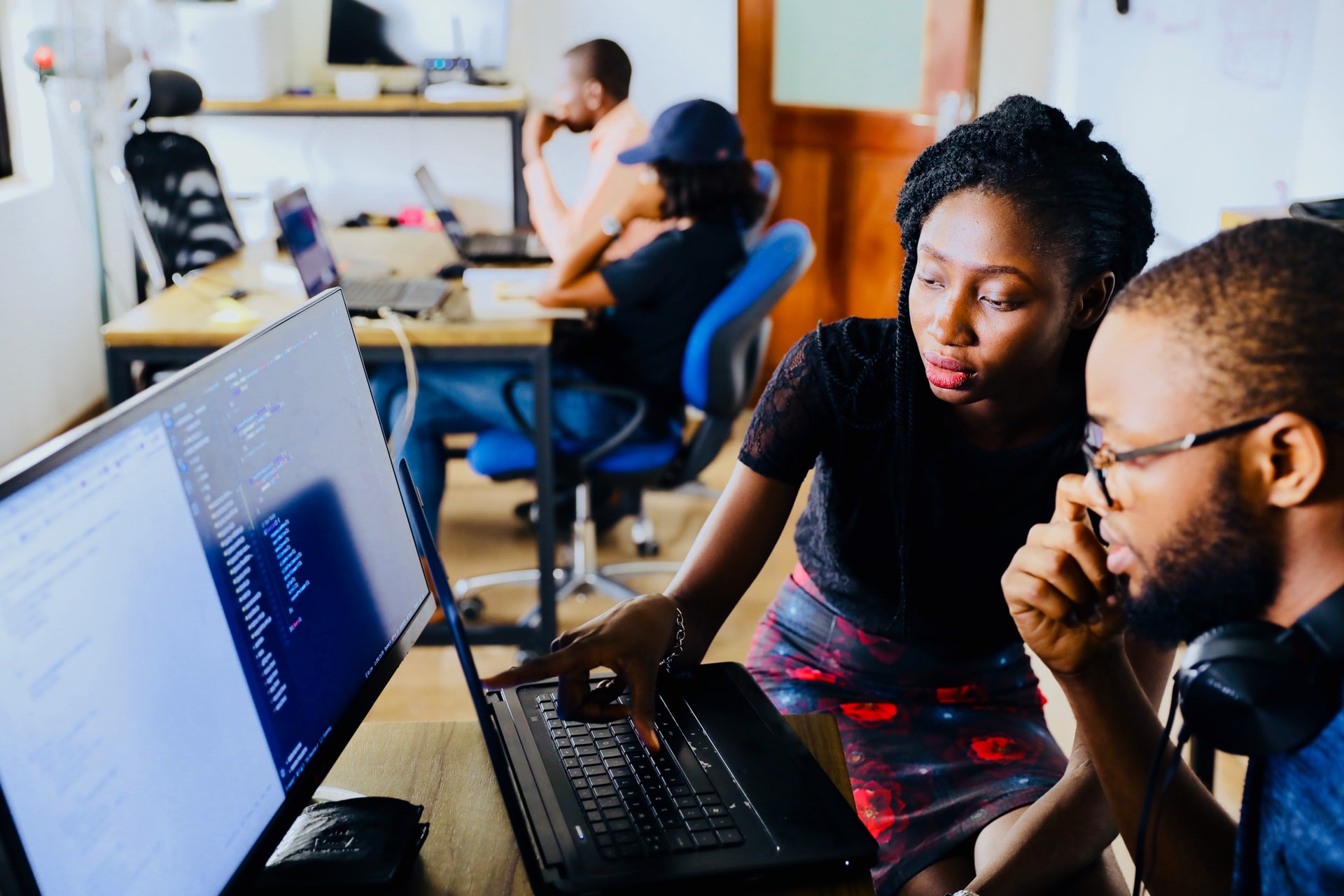 University or college professor helping a student with a question on the computer